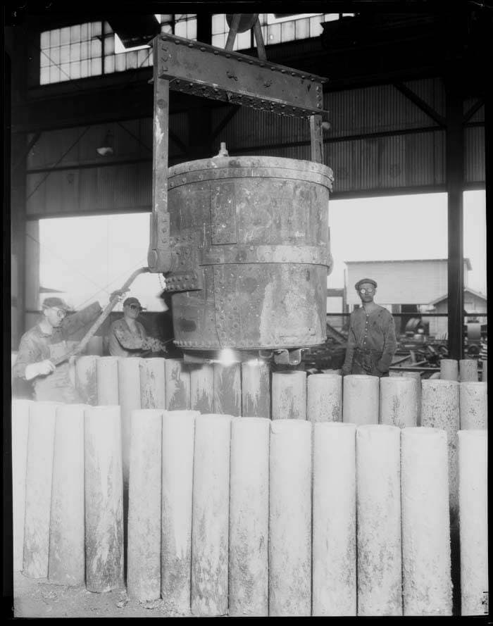 Industrial cold rolling mill processing stainless steel coil with visible tension rollers and precision gauges