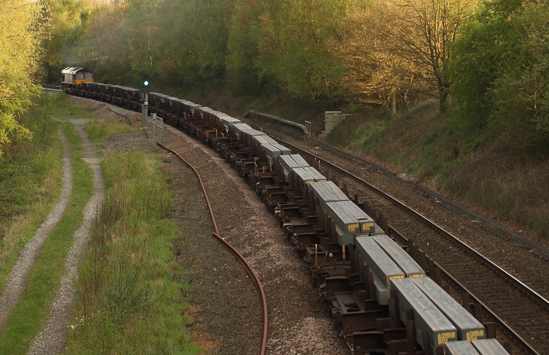 Close-up of a stainless steel sheet undergoing cold rolling in an industrial mill, showing deformation and surface texture.