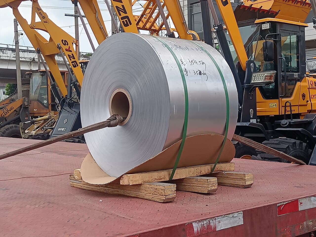 Truck carrying large industrial steel coils for procurement and delivery logistics