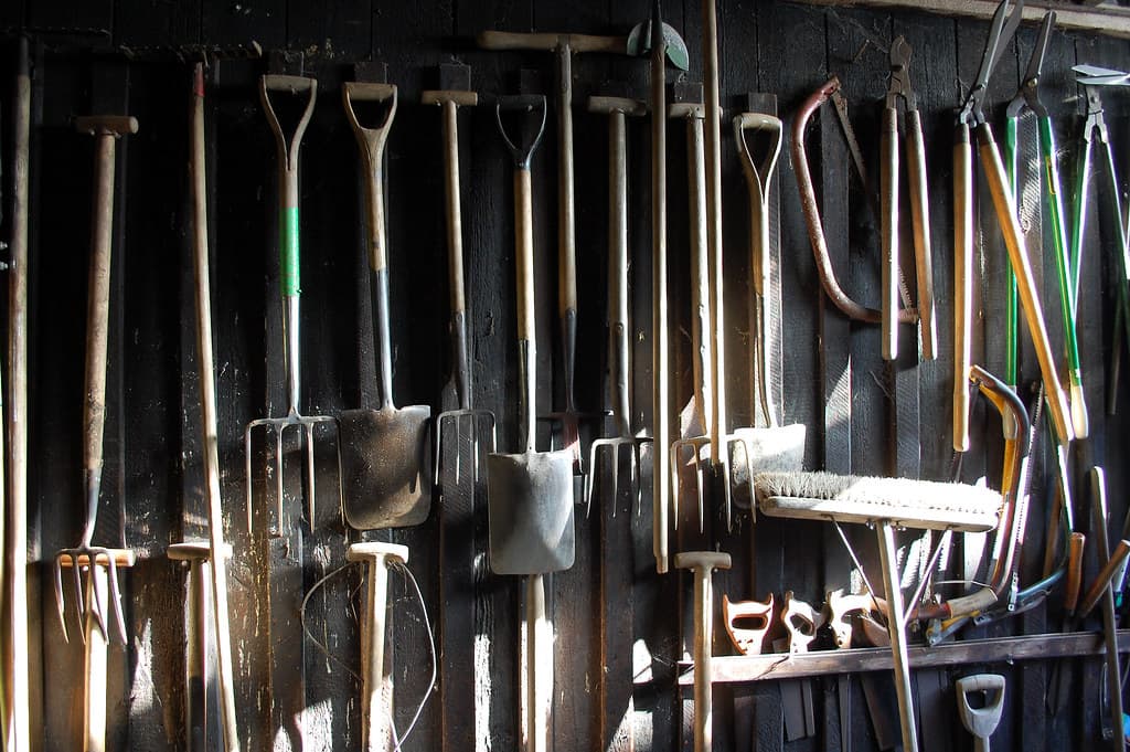 Stacked stainless steel coils labeled with mill test reports and batch numbers in a warehouse setting